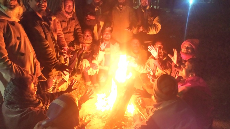 মধুপুরে  কাঠ নিয়ে  আগুন জ্বালিয়ে শীত নিবারণ করছে ছিন্ন মূল ম